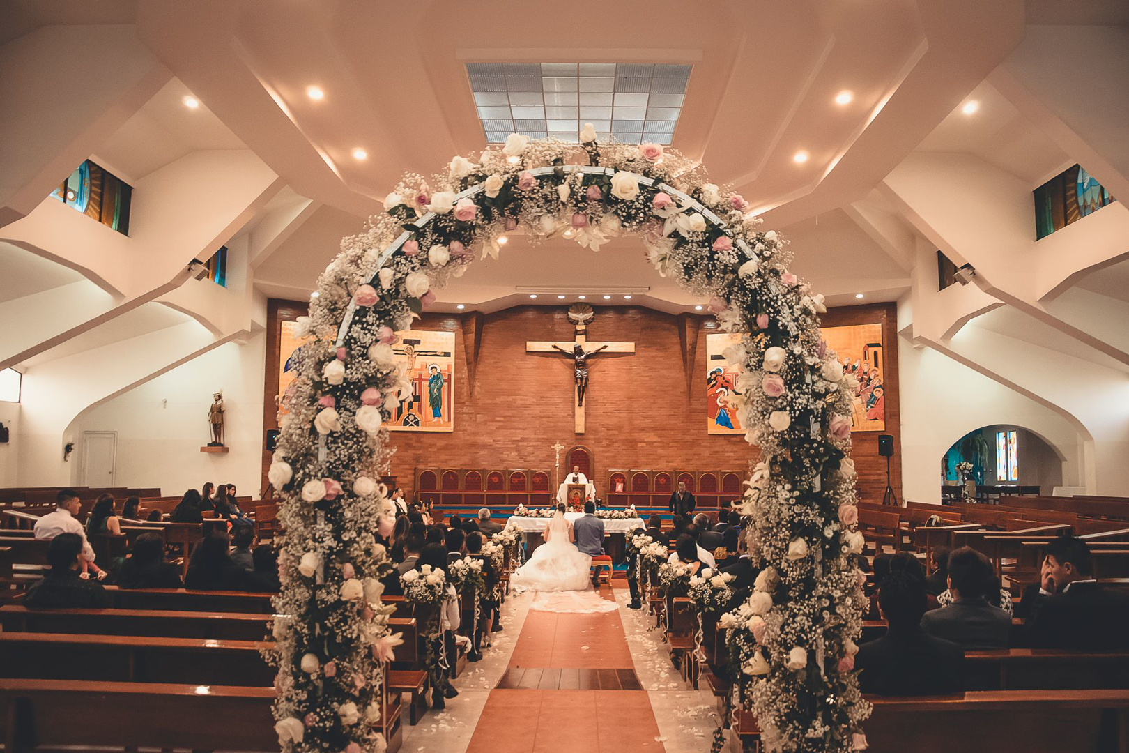 A flower-covered cross above the altar at Mount Olive