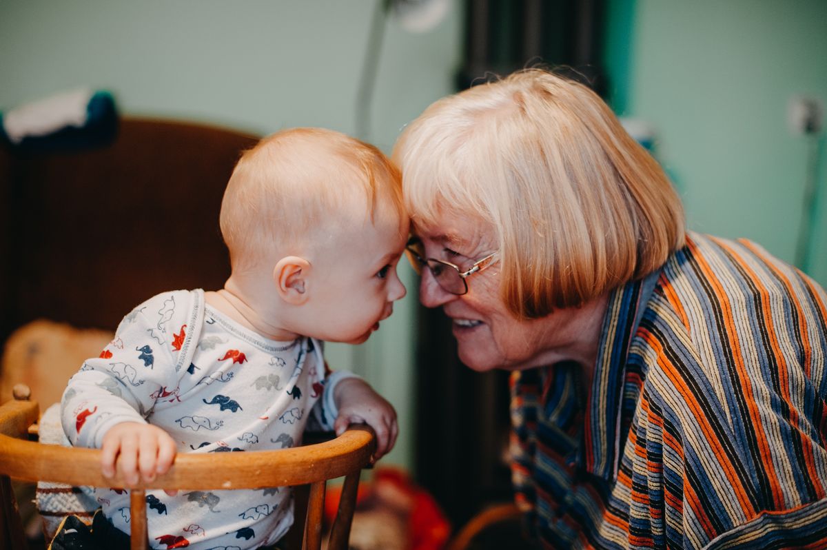 A grandmother holding a smiling baby