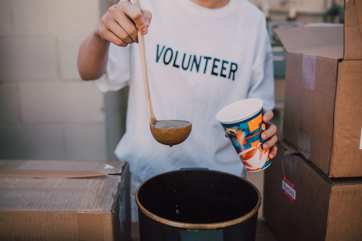 A volunteer serving soup
