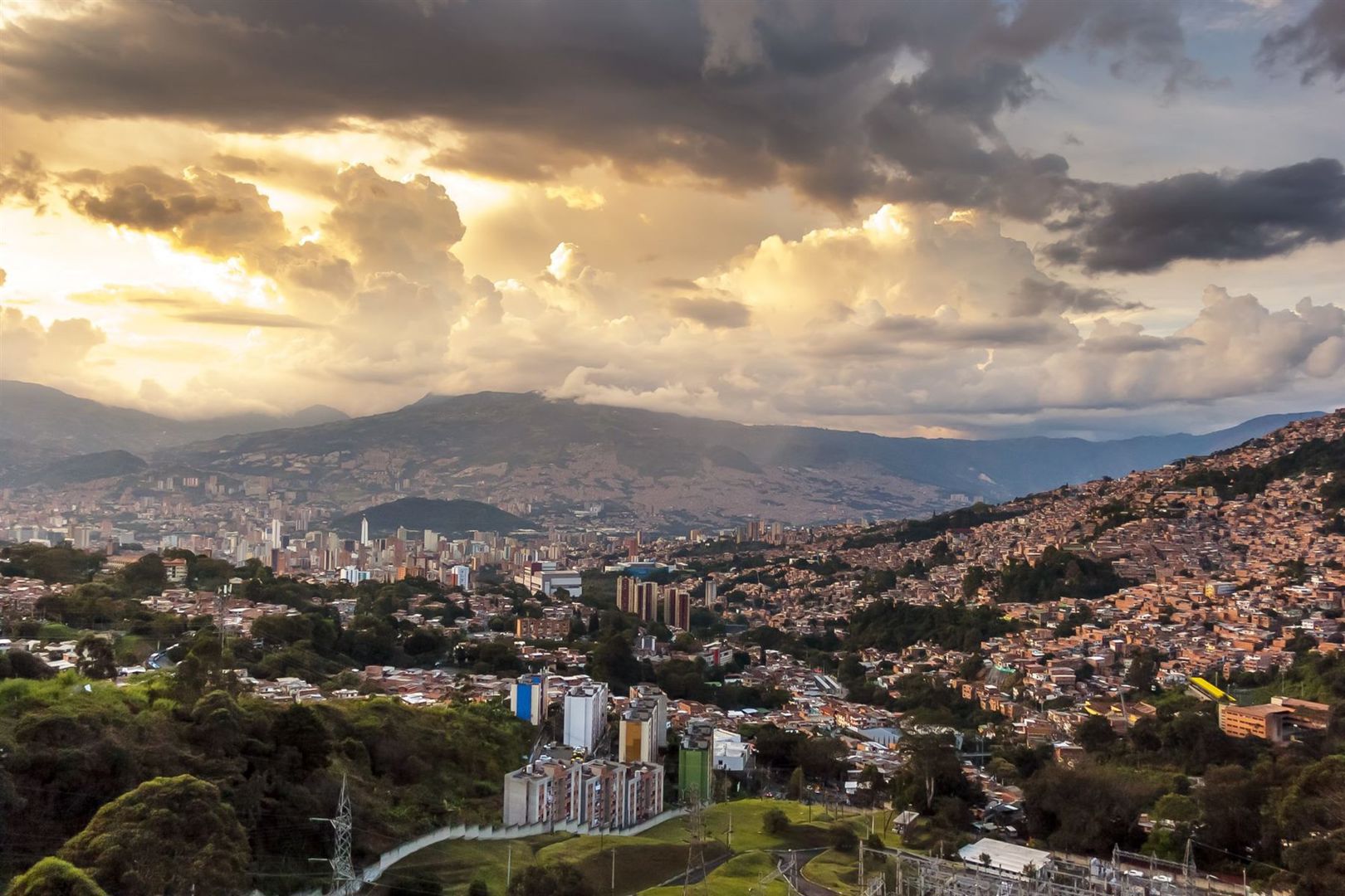 A hillside city in the Andes under a golden sky